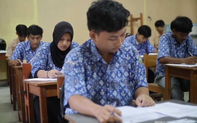 Students taking a test in a classroom representing GPA factors