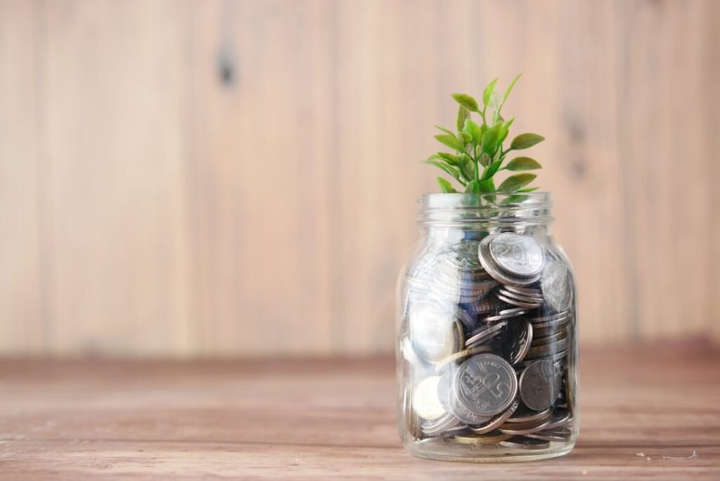 Jar of coins with a growing plant representing how compounding frequency affects investment returns