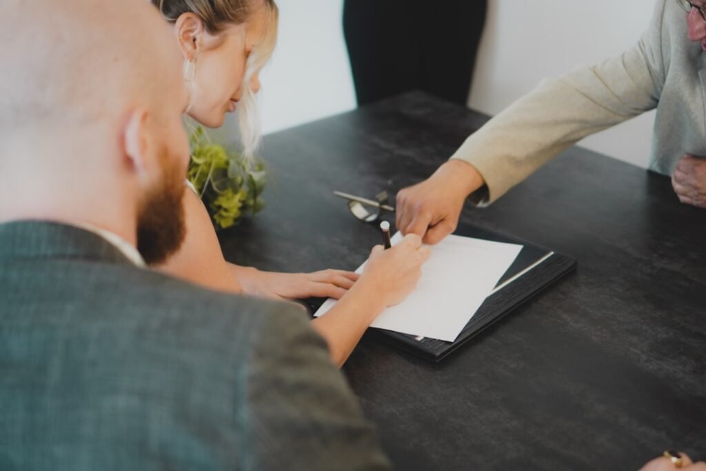 Couple signing mortgage documents at a desk