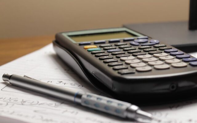 Calculator and pen on paper representing mental math percentage tricks
