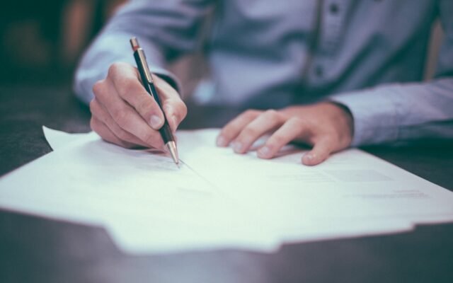 Person signing a document representing warning signs of a predatory loan