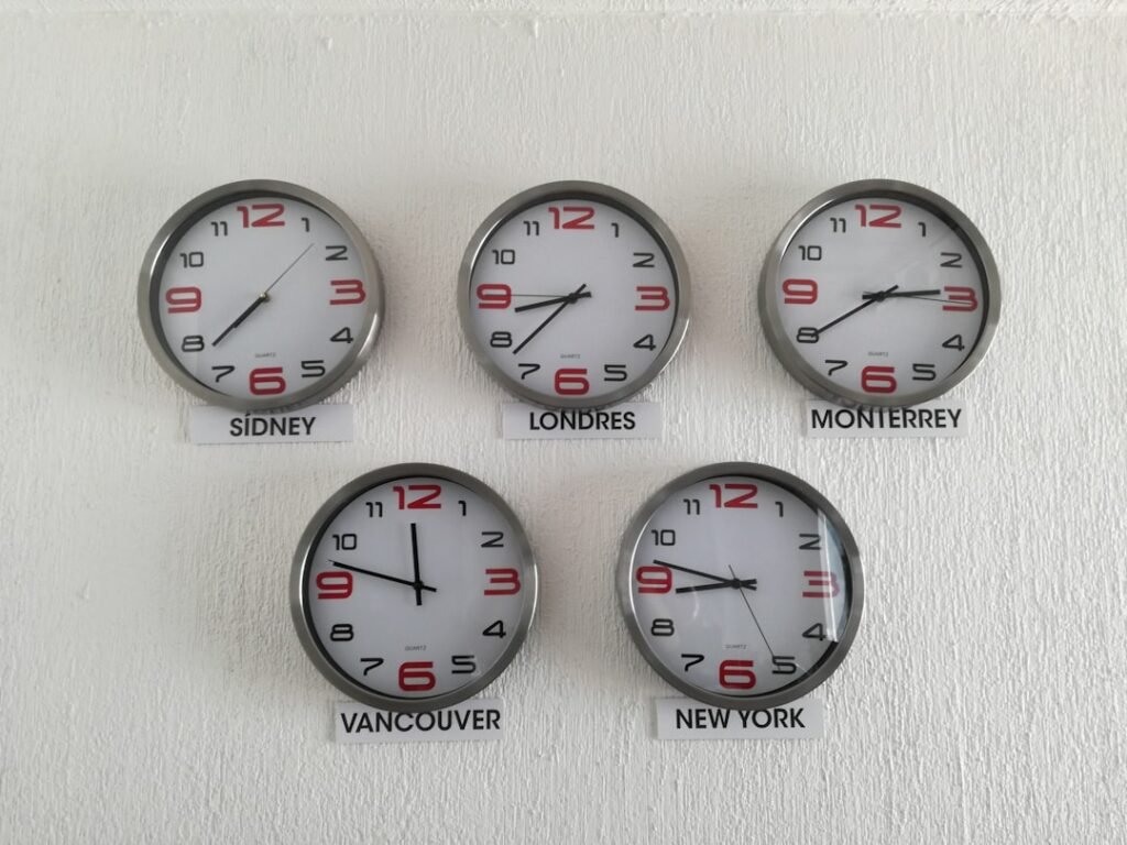 Wall clocks showing different time zones representing meeting scheduling mistakes