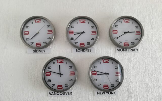 Wall clocks showing different time zones representing meeting scheduling mistakes