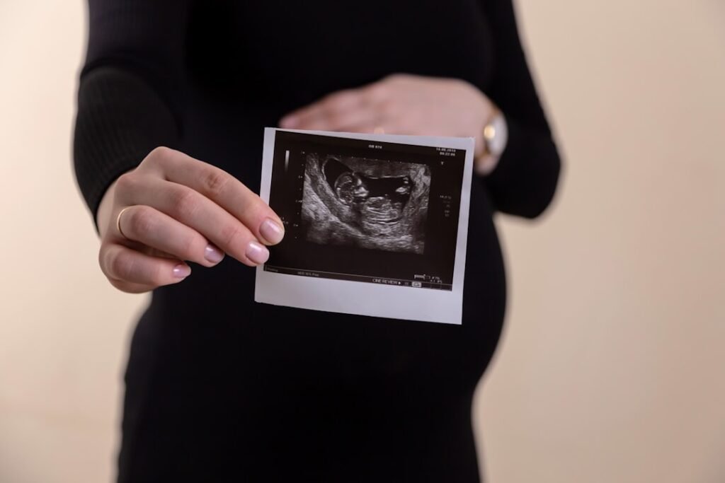 Pregnant woman holding an ultrasound picture representing due date accuracy
