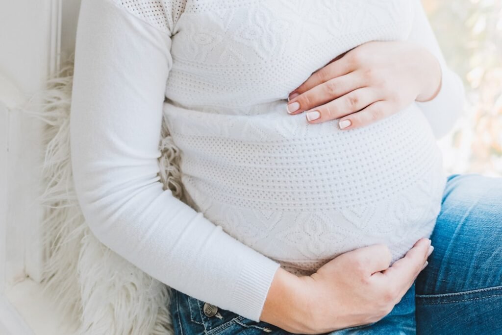Pregnant woman holding her belly representing pregnancy milestones by trimester